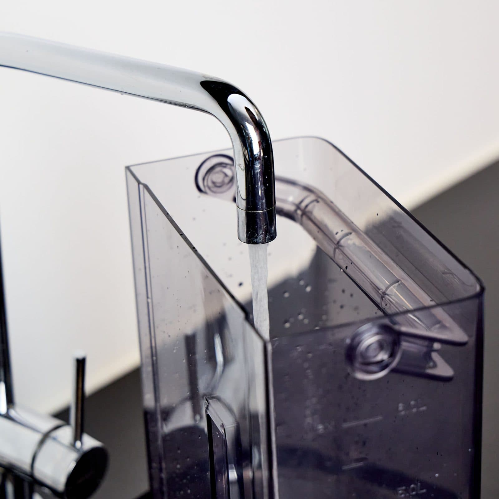 Filling the Aqua's removable water tank at a kitchen tap